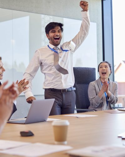Multi-Cultural Business Team Celebrating Deal Around Table In Modern Office Building Multi-Cultural Business Team Celebrating Deal Around Table In Modern Office Building